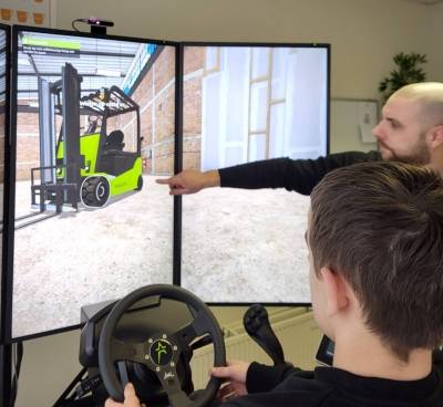 Leerkracht Maikel geeft uitleg bij de heftrucksimulator